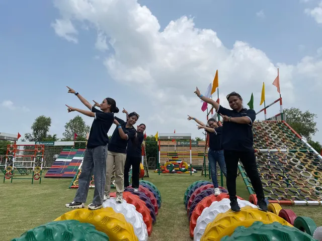 Colleagues balancing along a row of painted tyres on the adventure course at Pratapgarh Farms